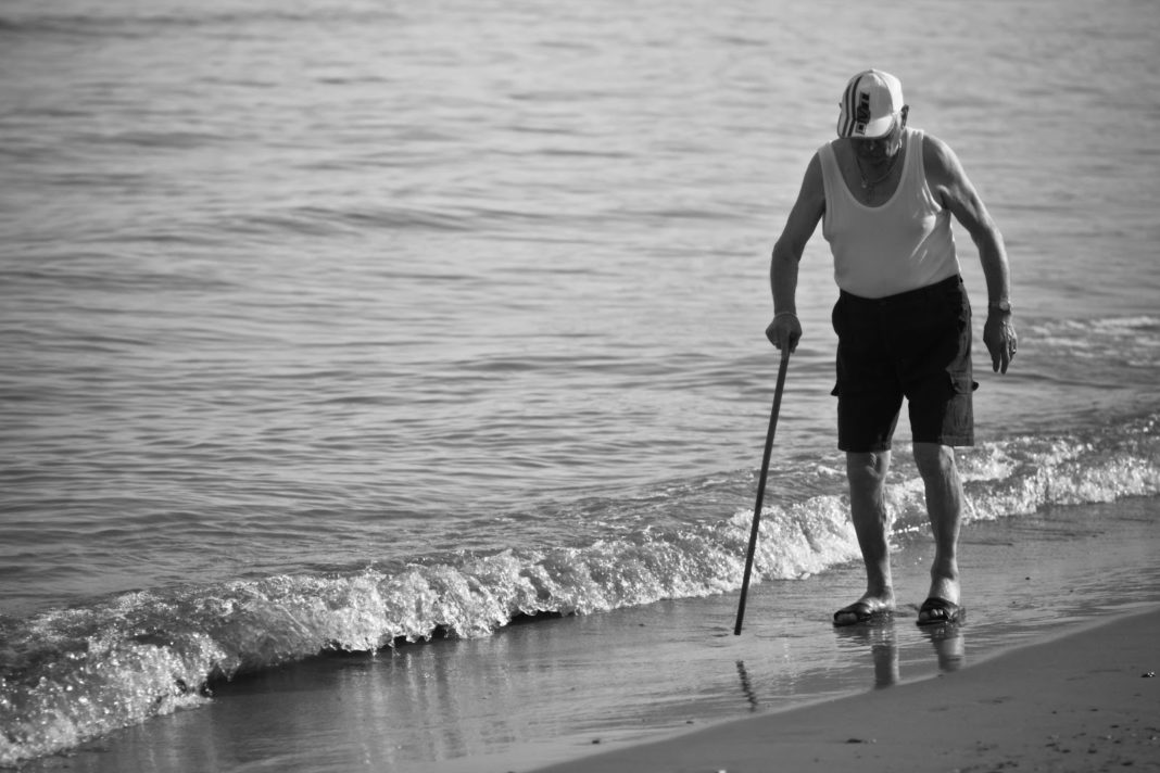 anziano sulla riva di una spiaggia