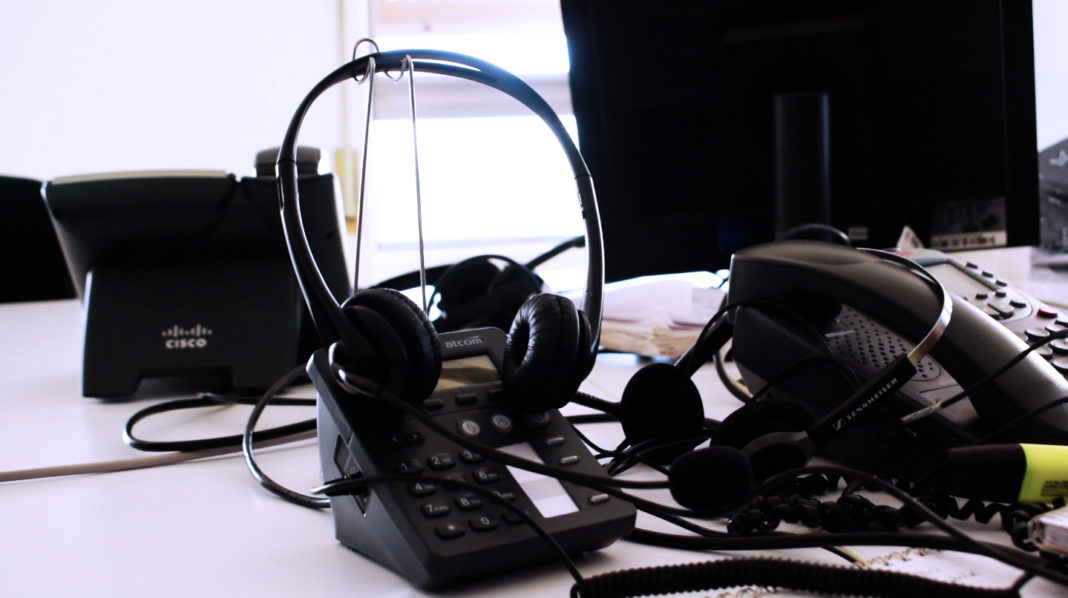 cuffie e telefoni su una scrivania di un help desk
