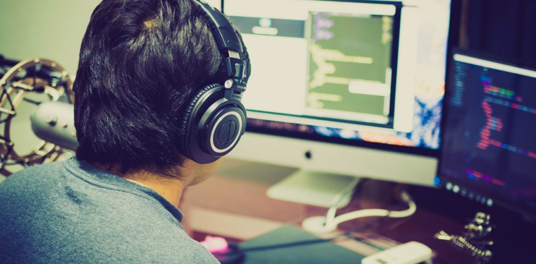 uomo che lavora al pc con le cuffie